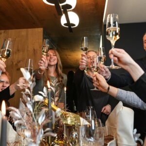 Eine fröhliche Runde feiert Silvester mit Sektanstoßen und Konfetti im mamazita